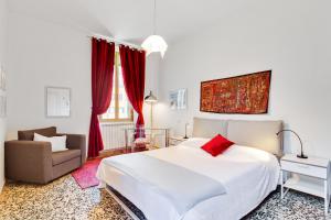 sypialnia z dużym białym łóżkiem i krzesłem w obiekcie Accogliente appartamento a Dorsoduro con GIARDINO! w Wenecji