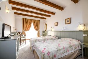 a bedroom with two beds and a tv and a window at Pensiunea Casa Nostalgia in Bran