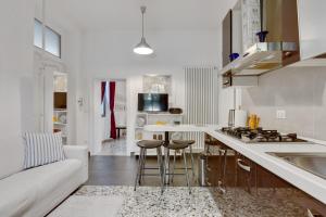 a white kitchen with a white couch and a counter top at Accogliente appartamento a Dorsoduro con GIARDINO! in Venice