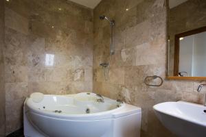 a bathroom with a bath tub and a sink at The Islay Hotel in Port Ellen