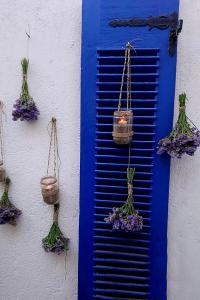 une porte bleue avec des pots de fleurs et un volet bleu dans l'établissement Small traditiional home near the shops and restaurants in Korissia, Kea, à Ioulída