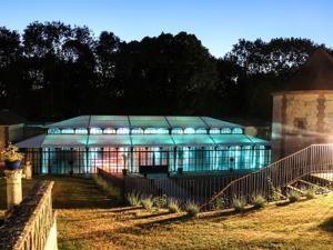 ein großes Gebäude mit einem Zaun davor in der Unterkunft Domaine de Montchevreuil in Fresneaux-Montchevreuil