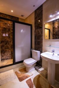 La salle de bains est pourvue de toilettes, d'un lavabo et d'un miroir. dans l'établissement Hotel Toulousain, à Marrakech