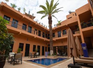 ein Hotel mit Palme und Swimmingpool in der Unterkunft Hotel Toulousain in Marrakesch