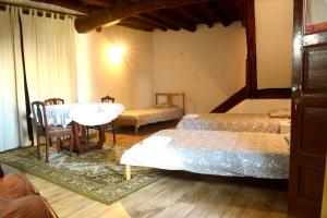 Un dormitorio con dos camas y una mesa y sillas. en casa das pombas, en Barcelos