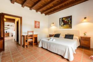 a bedroom with a bed and a desk and a table at Villa Can Curreu in Sant Carles de Peralta