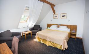 a bedroom with a bed and two chairs in a room at Vihula Manor Country Club & Spa in Vihula