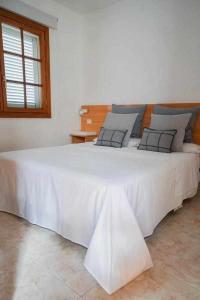 a large white bed in a room with a window at Los Tunos 81 Air conditioned 1 bedroom in Maspalomas