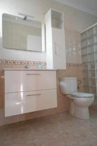 y baño con aseo blanco y espejo. en Los Tunos 81 Air conditioned 1 bedroom, en Maspalomas