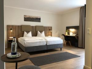 Un dormitorio con una cama y una mesa con una botella. en Anderschitz Landhotel, en Neufarn