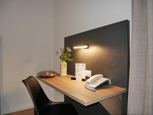 a desk with a phone on top of it at Anderschitz Landhotel in Neufarn