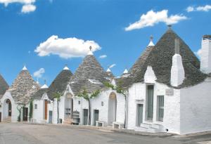 una fila de edificios blancos con techos puntiagudos en Tipico Resort en Alberobello