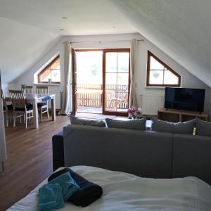Sala de estar con sofá, TV y mesa en Rhönpanorama en Hilders