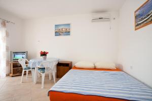 sypialnia z łóżkiem i stołem z krzesłami w obiekcie Apartments Mato w Krku