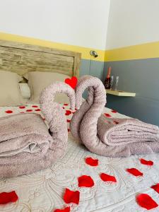 a bed with two towels and red roses on it at Chambres d'hôtes l'Orchidée Rose in Salazie