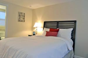 1 dormitorio con 1 cama blanca grande con almohadas rojas en Siesta Key Beach - Capri 665 #4, en Siesta Key