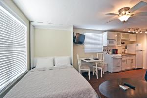 1 dormitorio con cama, mesa y cocina en Siesta Key Beach - Capri 665 #4, en Siesta Key