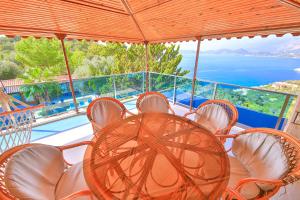 a table and chairs on a balcony with a view of the ocean at Villa Dundar - Kas Apartments in Kas