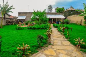 un giardino con sentiero in pietra di fronte a un edificio di Dan Stam Hotel ad Arusha