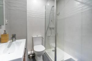 La salle de bains blanche est pourvue d'une douche et de toilettes. dans l'établissement Logement Noah, à Courcouronnes