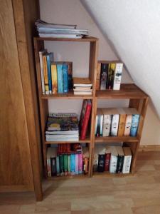 a book shelf filled with books next to a staircase at Ferienwohnung am Küstenwald in Trassenheide