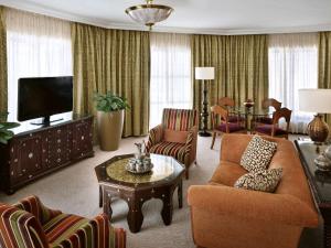 a living room with a couch and chairs and a television at Mövenpick Resort Petra in Wadi Musa