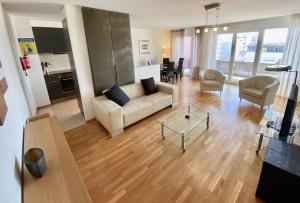 Spacious and bright 2 bedroom apartment with terrace في لوزان: غرفة معيشة مع أريكة وطاولة