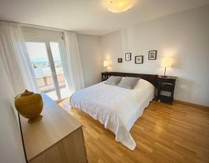una camera bianca con un letto e una grande finestra di Spacious and bright 2 bedroom apartment with terrace a Losanna