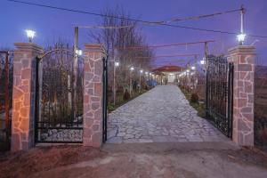 um portão para uma entrada com luzes à noite em Vila 1 em Korçë
