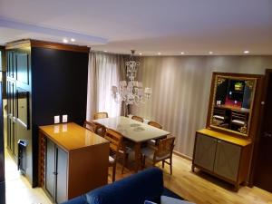 a dining room with a table and a mirror at Apartamento Knorrville 306 in Gramado