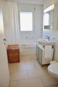 a white bathroom with a sink and a toilet at Comfortable, sunny, quiet, good location! in Lausanne