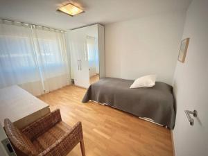 ein Schlafzimmer mit einem Bett, einem Tisch und einem Stuhl in der Unterkunft Modern, bright and spacious 3 bedrooms 2 bathrooms in Lausanne