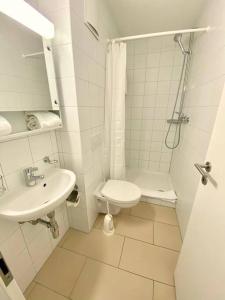 a white bathroom with a toilet and a sink at Good location, spacious, comfortable and bright!! in Lausanne