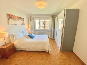 ein Schlafzimmer mit einem weißen Bett und einem Fenster in der Unterkunft Near the lake and city center ! in Lausanne