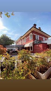 um edifício vermelho com plantas em frente em Locanda Damaro em Vicenza