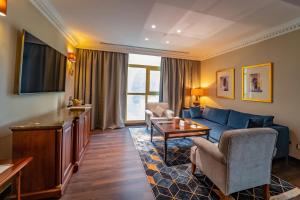 a living room with a blue couch and a table at Millennium Hotel Doha in Doha