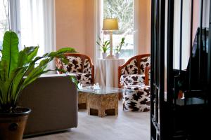 een woonkamer met 2 stoelen en een tafel bij Hotel Sully in Nogent-le-Rotrou