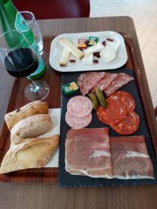 a tray of meats and cheese and a glass of wine at Campanile Saintes in Saintes