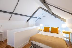 um quarto com uma cama com almofadas amarelas em Villa Graça -Hostels and Apartments em Santarém