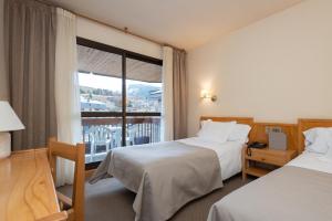 um quarto de hotel com duas camas e uma janela em Hotel Bonavida em Canillo