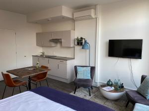 Cette chambre comprend un lit, une table et une cuisine. dans l'établissement Hotel Oranjestaete, à Nimègue