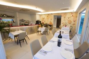 a restaurant with white tables and chairs and a bar at Ocean Lounge in Altea