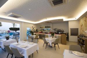 a restaurant with white tables and chairs and a kitchen at Ocean Lounge in Altea