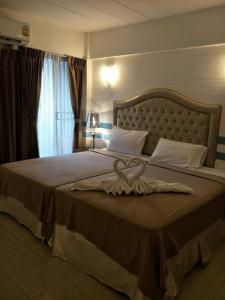 a bedroom with a large bed with a large headboard at I-Inn Hotel in Bangkok