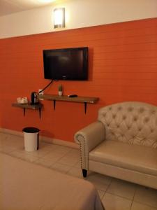 a living room with a chair and a television at I-Inn Hotel in Bangkok