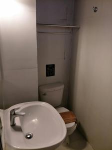 a bathroom with a white sink and a toilet at I-Inn Hotel in Bangkok