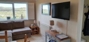 un soggiorno con divano e TV a schermo piatto di Ocean's Edge a Perranporth