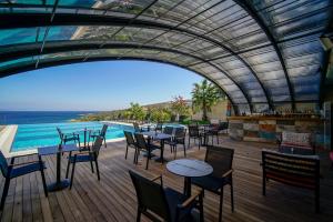 een restaurant met tafels en stoelen en uitzicht op de oceaan bij Cape Krio Boutique Hotel & SPA - Over 9 years old Adult Only in Datca