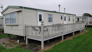 a mobile home with a porch and a deck at 8 Berth Northshore Skegness The Cottage Panel heated in Lincolnshire