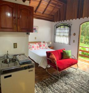 a kitchen with a bed and a sink in a room at Chalés Lua de Mel in Monte Verde +9 photos